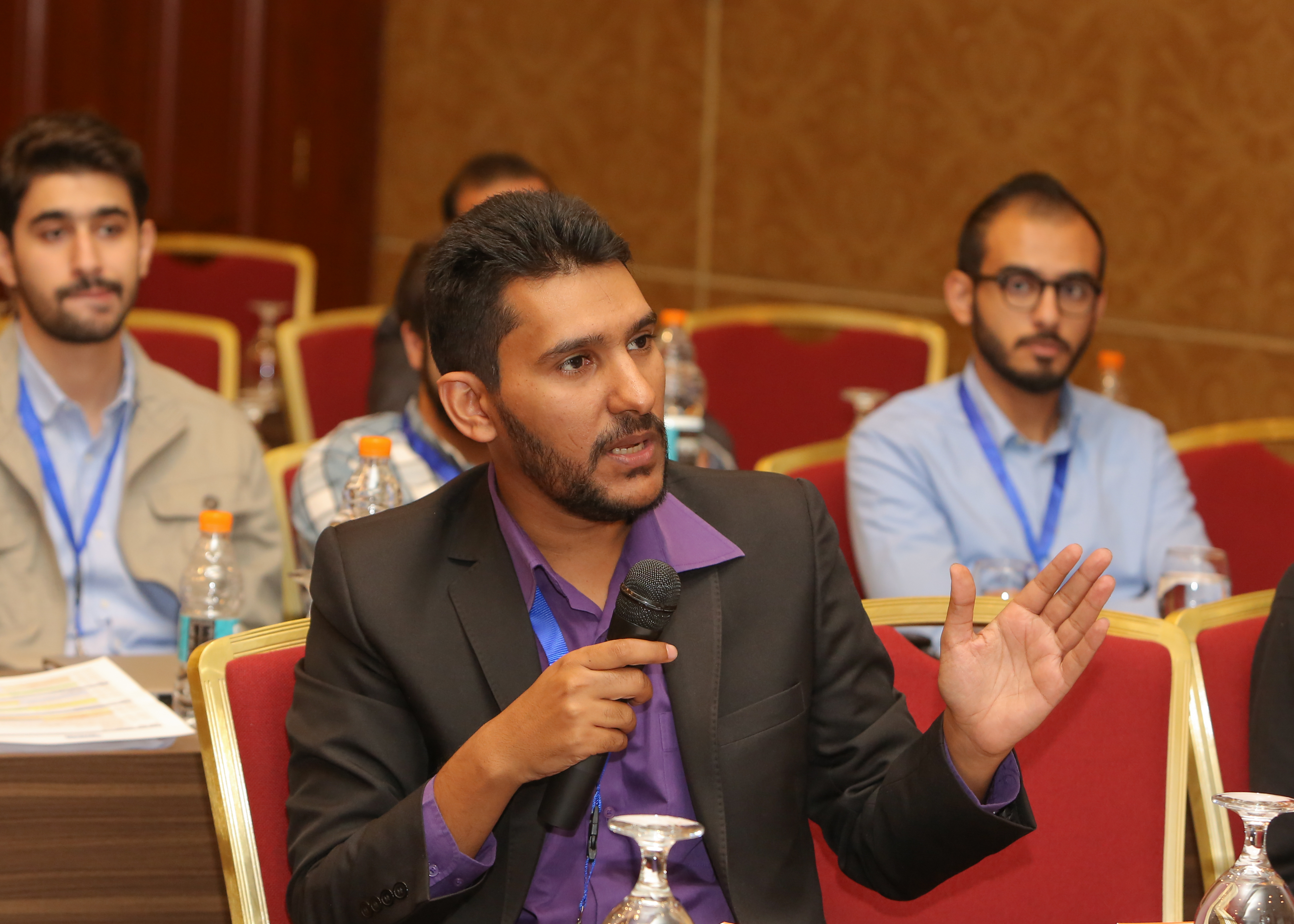 Muayyad Alsadi speaking into a microphone at a conference.