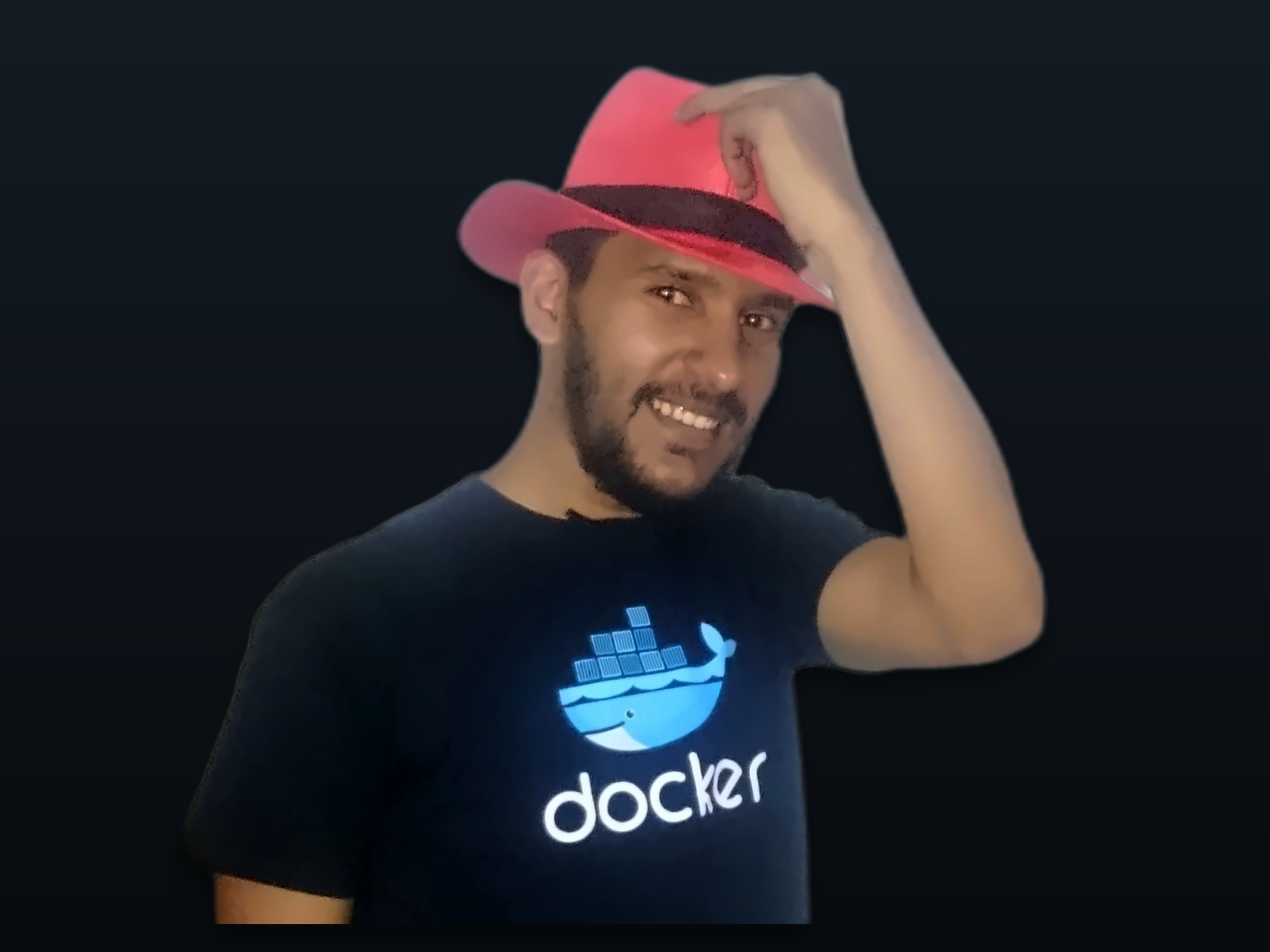 Muayyad Alsadi in a Docker shirt and a red hat.